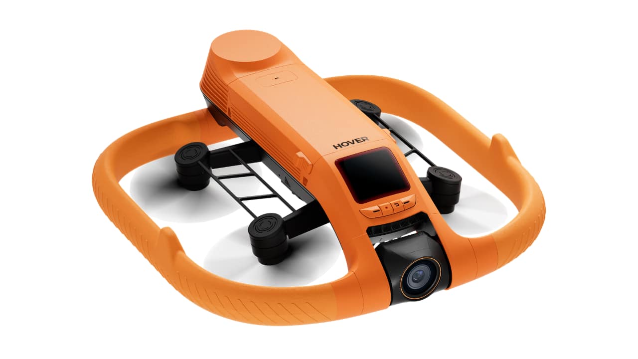 HOVERAir AQUA waterproof self-flying camera viewed from above, showing the orange buoyancy frame, four propeller arms, gimbal camera, and on-device screenHOVERAir AQUA waterproof self-flying camera viewed from above, showing the orange buoyancy frame, four propeller arms, gimbal camera, and on-device screen