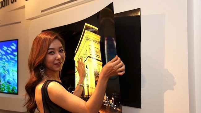 A model unpeels a 55in LG Display screen from the wall LG Display