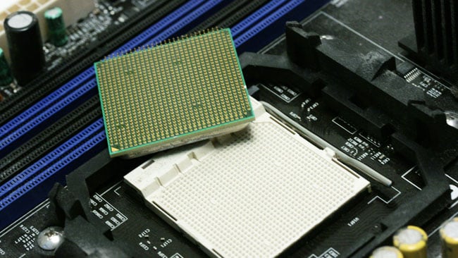 The CPU (shown upside down, revealing the pins) must fit the socket on the motherboard.JPG