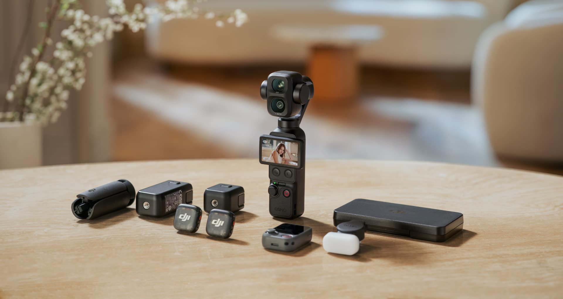 DJI Osmo Pocket 4P camera on a table surrounded by ND filters, battery handle, wide-angle lens, and carrying case