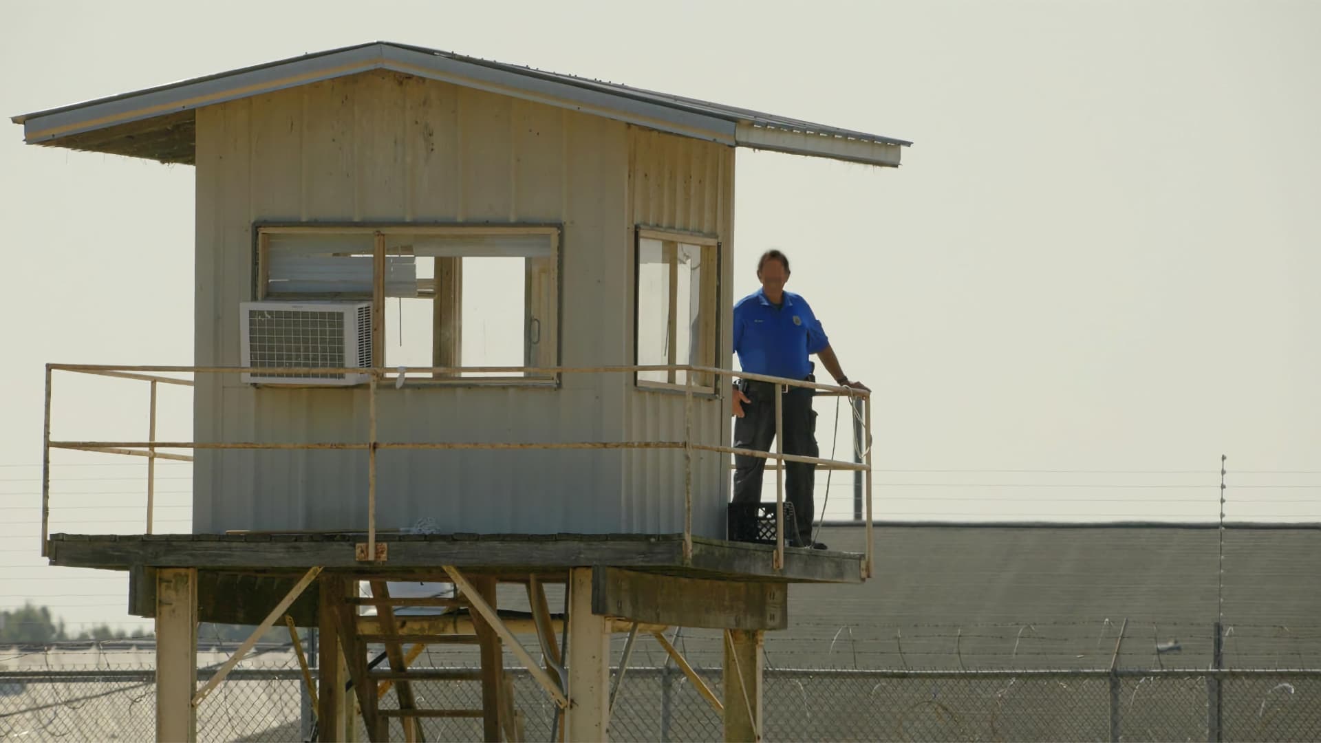 A distant guard on a prison watchtower in The Alabama Solution