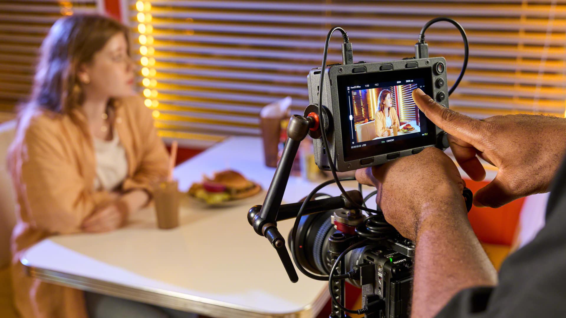 Sony RM-DP5 mounted on a camera rig monitoring an interview scene with an operator setting autofocus