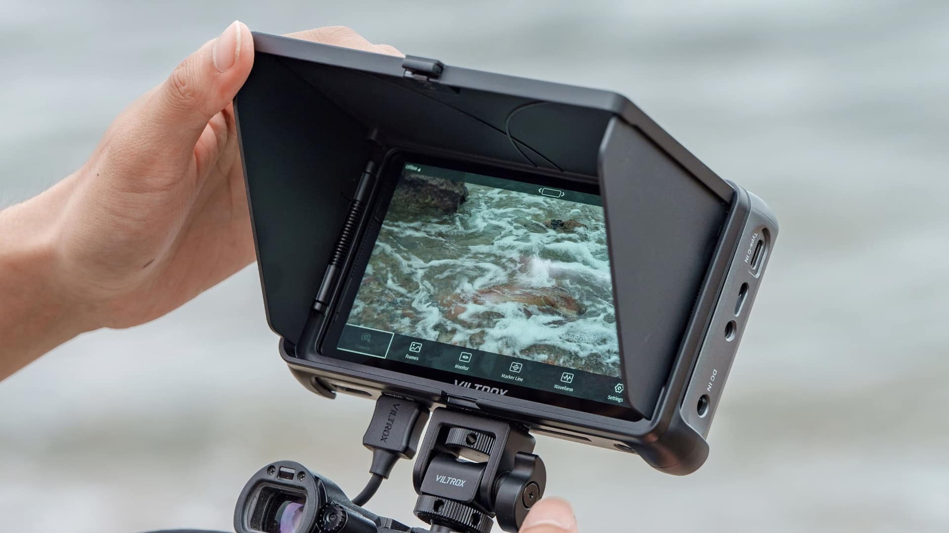 Viltrox DC-550 Pro II portable field monitor with sun hood fitted