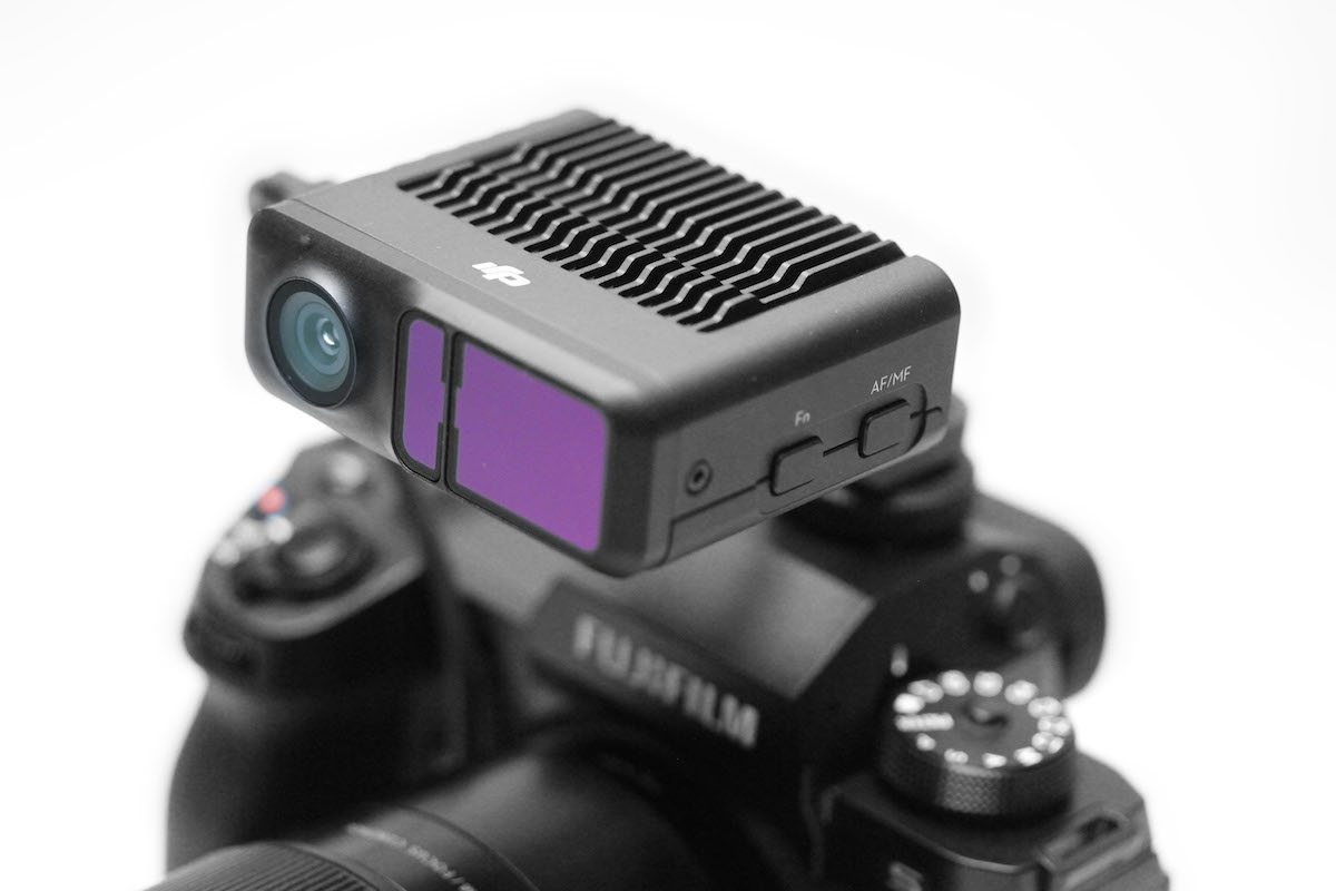 The lidar module rides on the Fujifilm X-H2S. the round lens is the witness camera; the smaller of the two purple coated windows has the laser emitter.