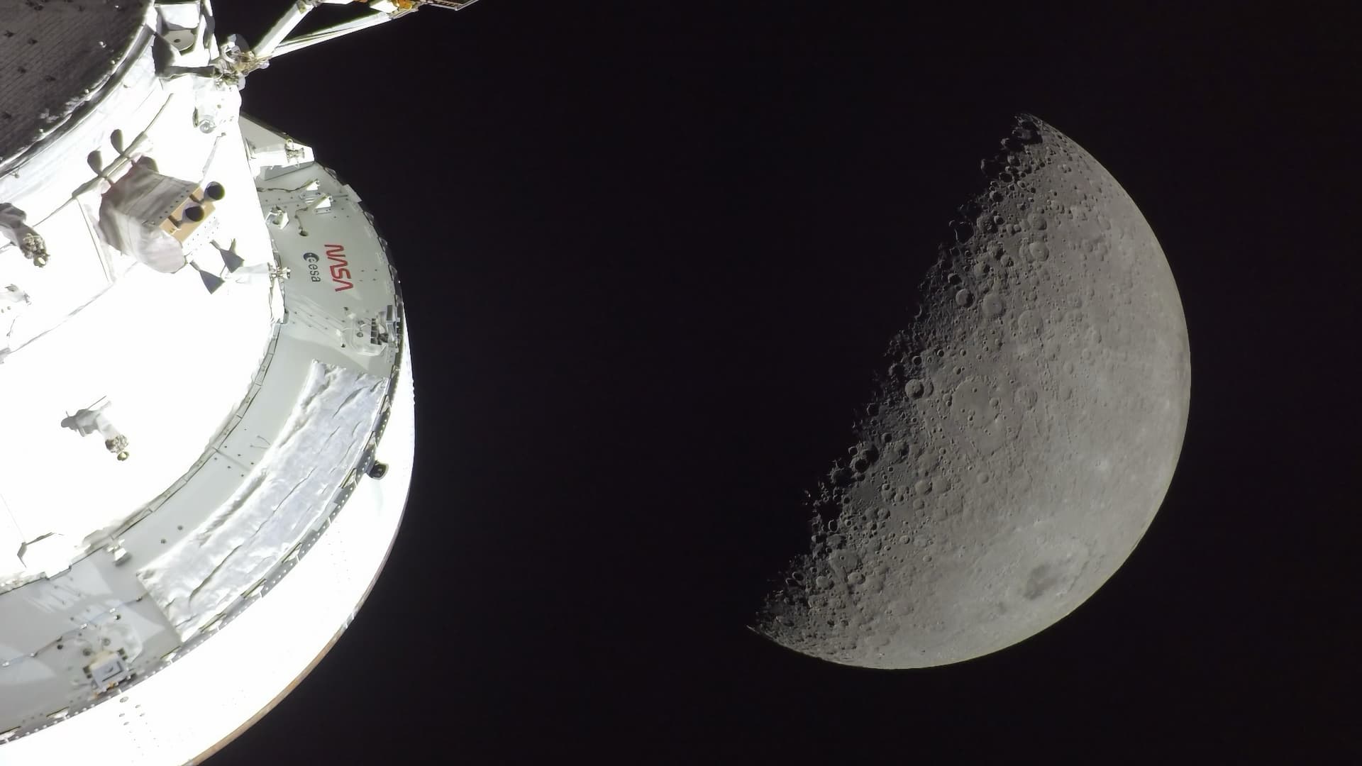 The Moon is photographed by a ruggedized GoPro HERO4 mounted on the Orion spacecraft’s solar array wing. 